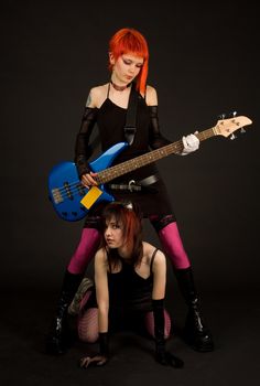 Two rock girls with guitar, studio shot 