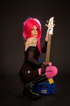 Attractive girl with bass guitar isolated on black background