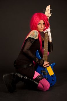 Romantic girl with bass guitar, studio shot 