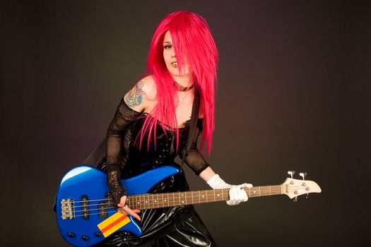 Attractive girl playing bass guitar isolated on black