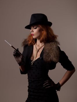 Gangster woman in fedora hat and evening dress holding mouthpiece 