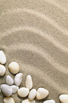 Sand background with stones for summer. Sandy beach texture. Macro shot. Copy space
