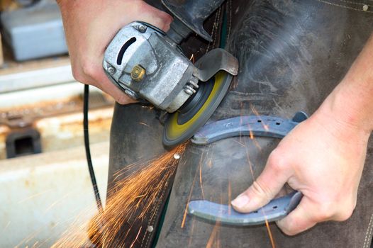 Blacksmith at work while changing a horseshoe