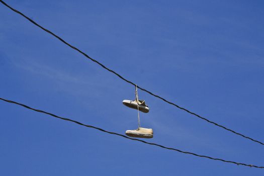 Schuhe hängen an Stromkabel