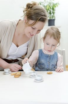 Mom and daughter having tea with bagels