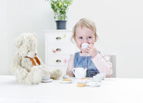 Child drink tea with bagels at home.