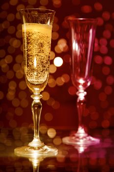 Two champagne glasses over colorful holiday bokeh background 