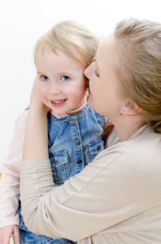 Attractive female and her daughter sharing secrets.