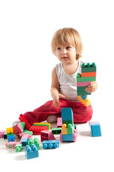 Funny boy playing with blocks, studio shot 