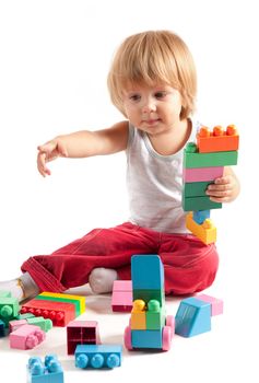 Cute little boy playing with blocks, isolated on white background 