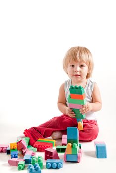 Funny little boy playing with blocks, studio shot 