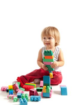 Smiling little boy playing with blocks, studio shot 