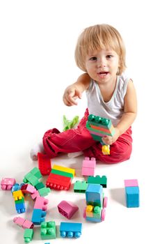 Smiling little boy playing with blocks, isolated on white background 