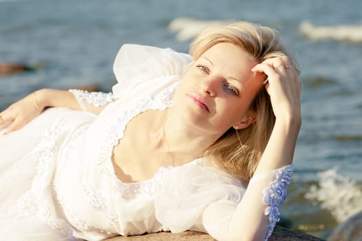 Woman lying on rock at seaside