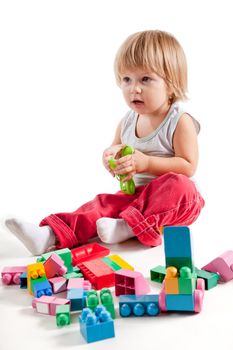 Cute little boy playing with colorful blocks, studio shot 