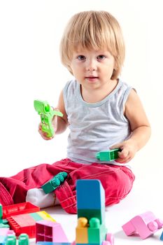 Cute little boy playing with blocks, isolated on white background 