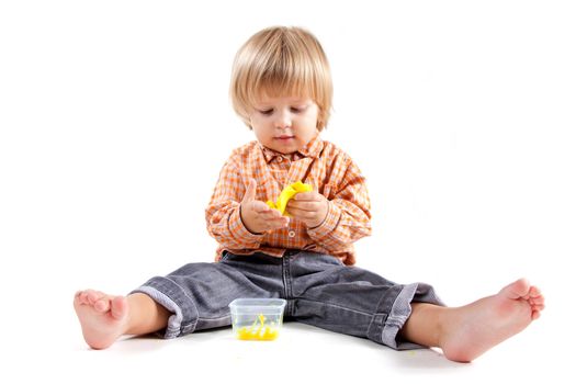 Cute little boy molding plasticine, isolated on white background 