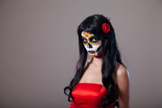 Sugar skull girl in red dress, studio shot 