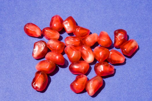 Red Pomegranate seeds on blue background.