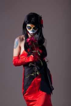 Sugar skull girl with rose, studio shot 