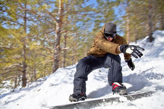 Snowboarder rides at high speed through the winter forest. Close-up. Motion Blur.