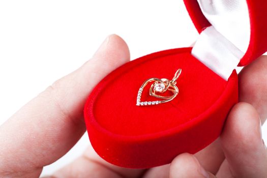 Red gift box with jewellery in a hand