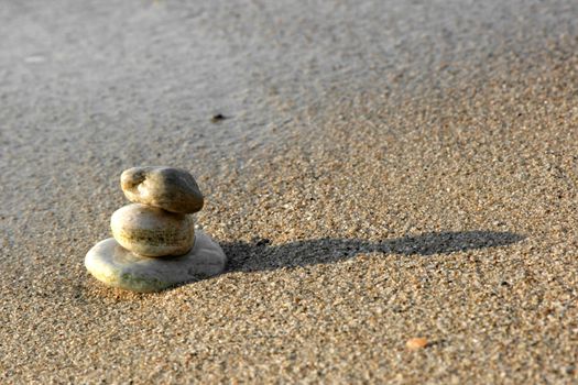Balanced stones on sand at seashore