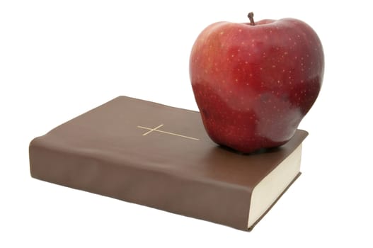 the bible and an apple on a white background