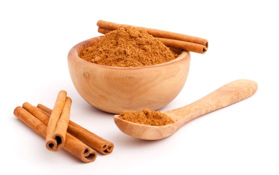 powder of cinnamon in wooden bowl with spoon and
Cinnamon sticks