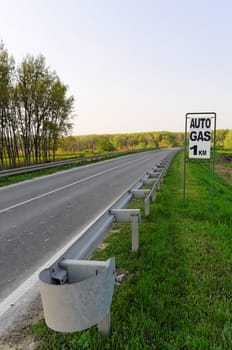 European asphalt road with auto gas sign ahead, vertical shot