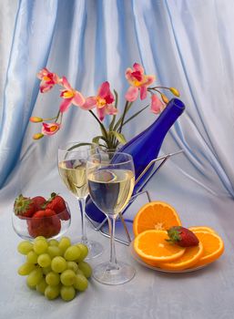 Two glasses of wine with fruits and orchid