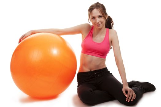 young sporty woman with a fitness ball on white background