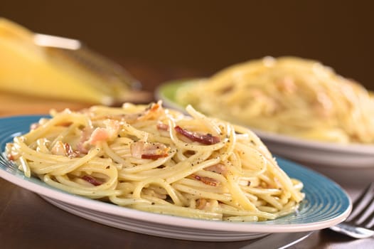 Spaghetti alla Carbonara made with bacon, eggs, cheese and black pepper (Selective Focus, Focus one third into the meal)