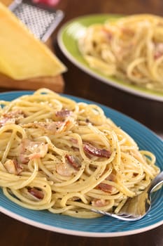 Spaghetti alla Carbonara made with bacon, eggs, cheese and black pepper (Selective Focus, Focus one third into the meal)