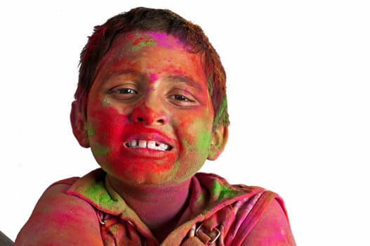 Close up face of young boy playing Holi, smiling with colors on face, Happy Child