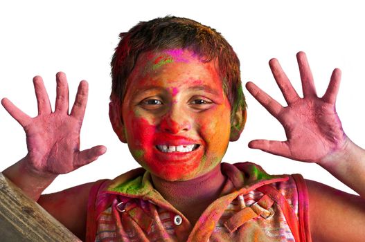 Close up face of young boy playing Holi, smiling with colors on face and hands