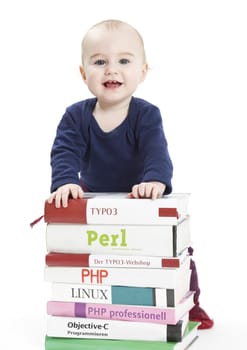 young child standing behind a stack of books. Isolated on white background