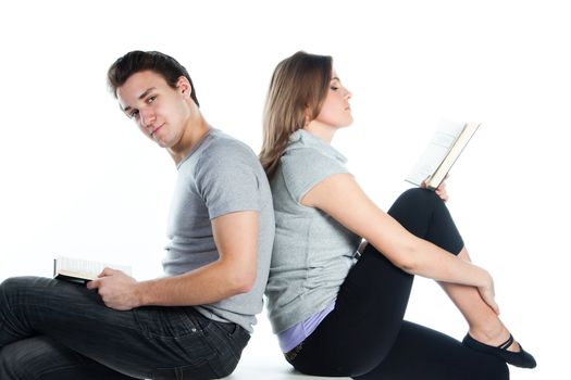 Young students - a boy and a girl reading a book and prepare for exams