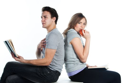 Young students - a boy and a girl reading a book and prepare for exams