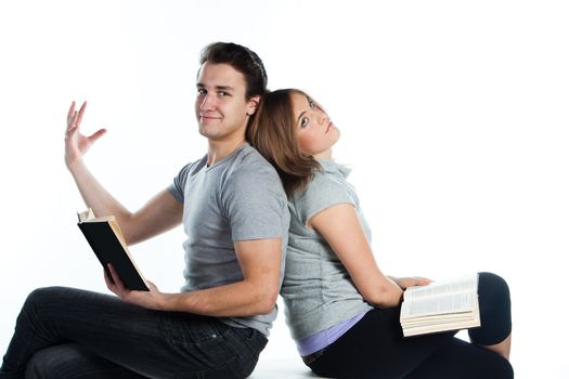 Young students - a boy and a girl reading a book and prepare for exams