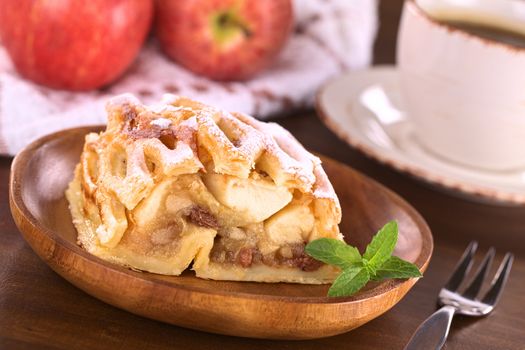 Apple strudel with raisins with coffee (Selective Focus, Focus on the left side of the apple-raisin stuffing and the front of the mint leaf)