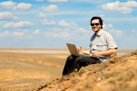 happy man with laptop on the hill