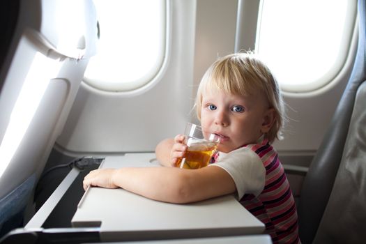 child with juice in airplane