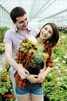 An image of a young couple with a flower pot