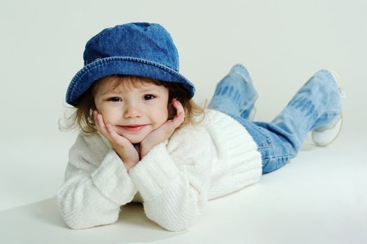 An image of a little girl in a hat and white jumper