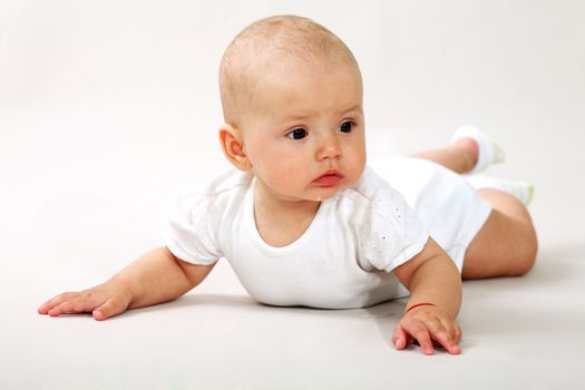 An image of a little baby-girl crawning in studio