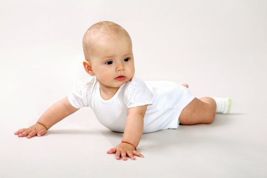 An image of a little baby-girl crawning in studio