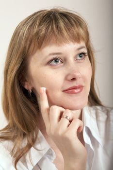 A girl putting a drop of cream on her cheek