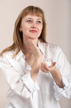A woman in white shirt with cream for make-up