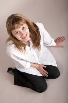 An image of nice girl in white shirt sitting on neutral background